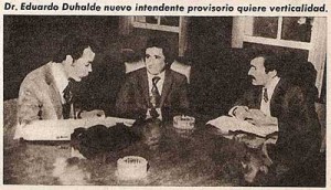 Eduardo Duhalde sentado en medio, con dos jefes de la Redacción de El Caudillo/Triple A 